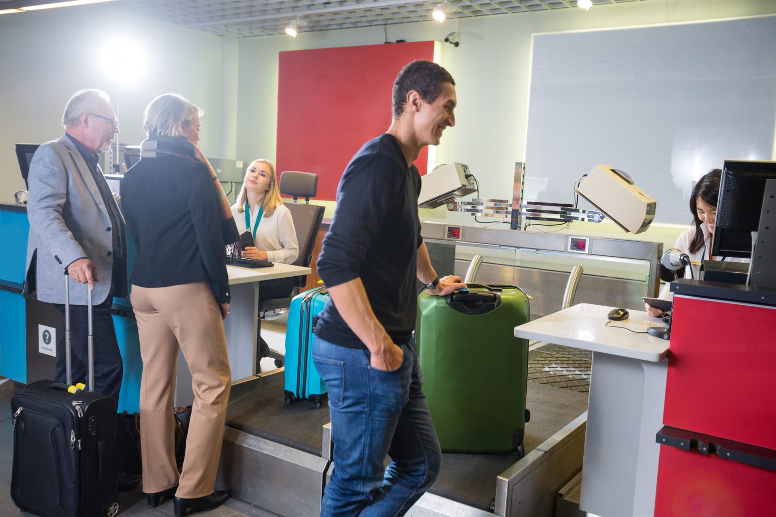 Travelers with suitcases at an airport check-in counter